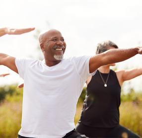 Senior man smiling during outdoor yoga class