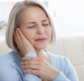 Senior holding woman ear in discomfort