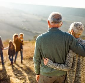 Elderly couple in a field with their family