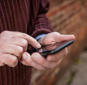 Elderly man's hands using smartphone