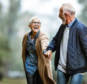 Senior couple holding hands and laughing