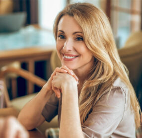 Middle-aged blonde woman smiling in restaurant
