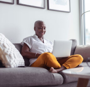 Stylish, senior woman sitting on sofa taking video call